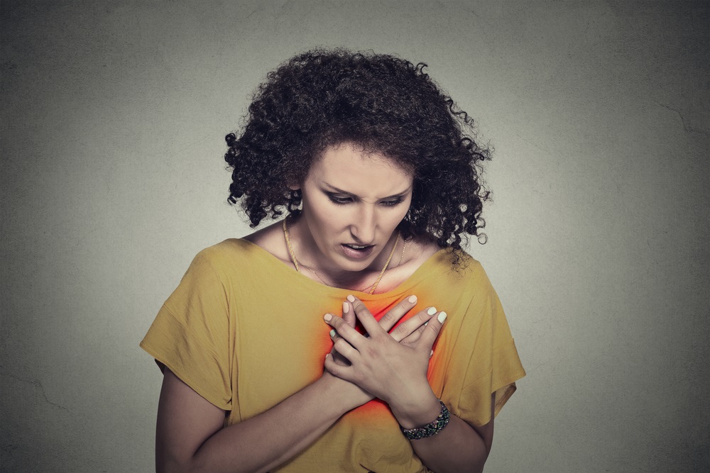 Woman with hand on chest heart disease
