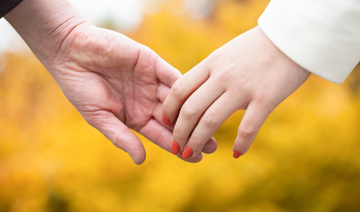 older couple holding hands, no rings