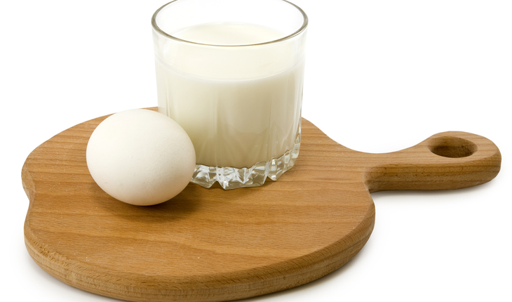 Isolated image of a glass of milk and an egg on the board