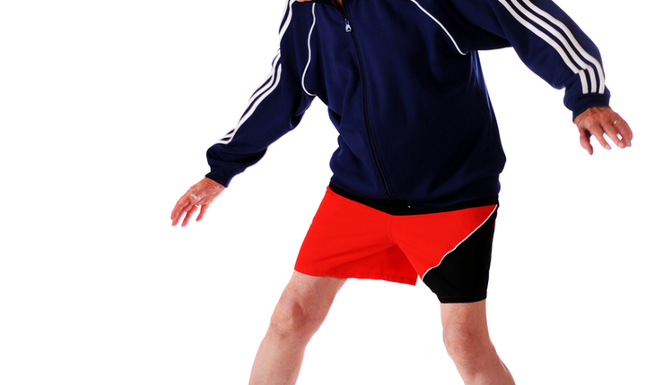 senior heading soccer ball