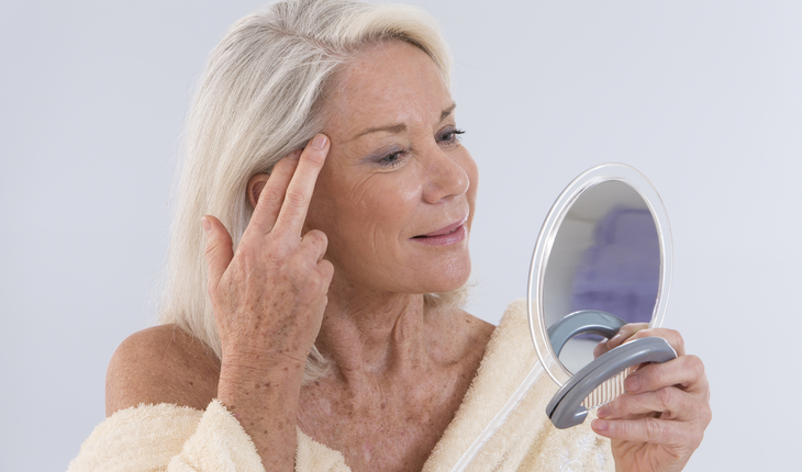 older woman looking in mirror