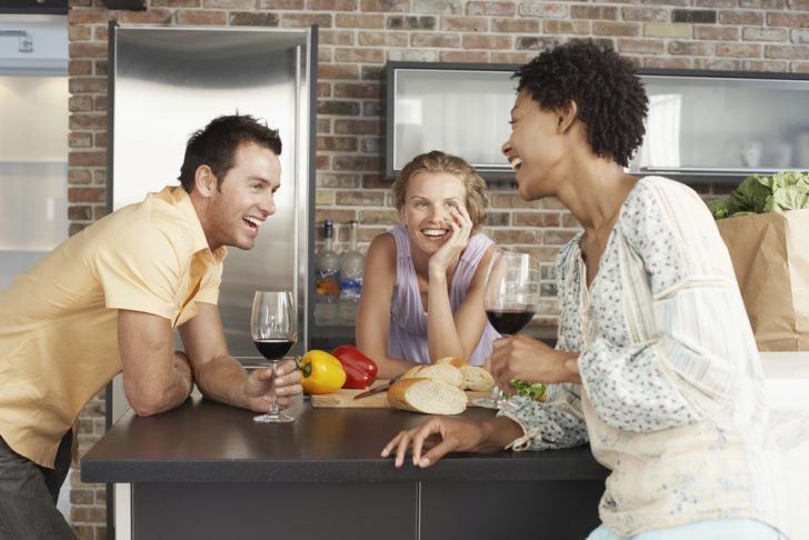 friends drinking in kitchen during party