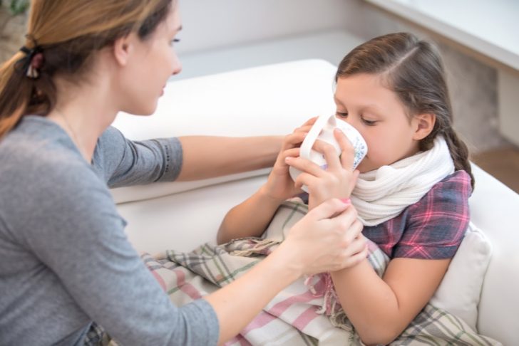 little girl with cold being treated by mothr