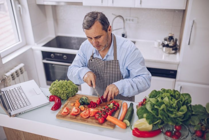 older man and healthy food in kitchen