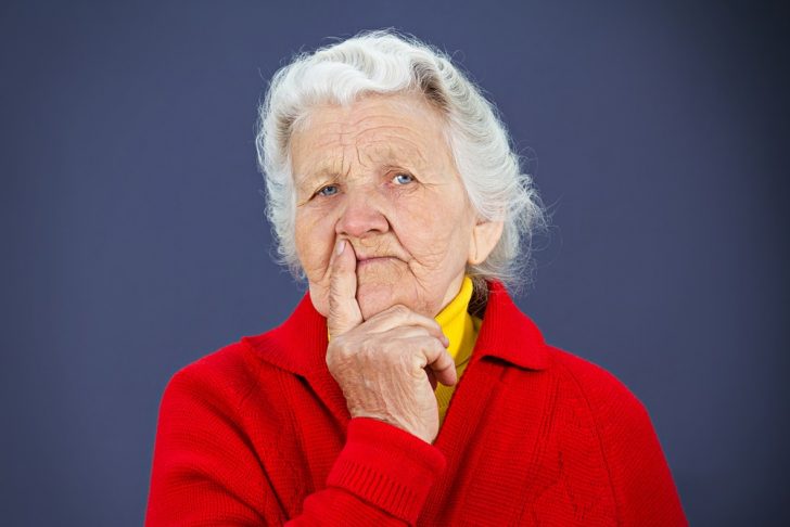 older woman, puzzled, red sweater