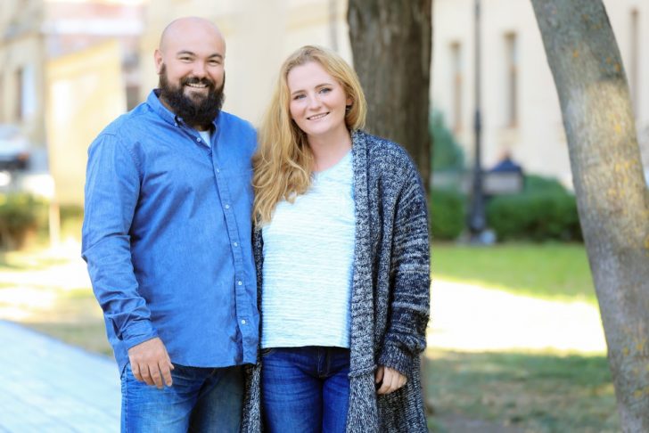 overweight couple standing by trees