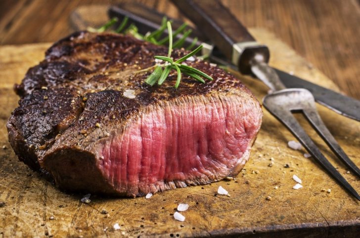 Cut of rare meat on table
