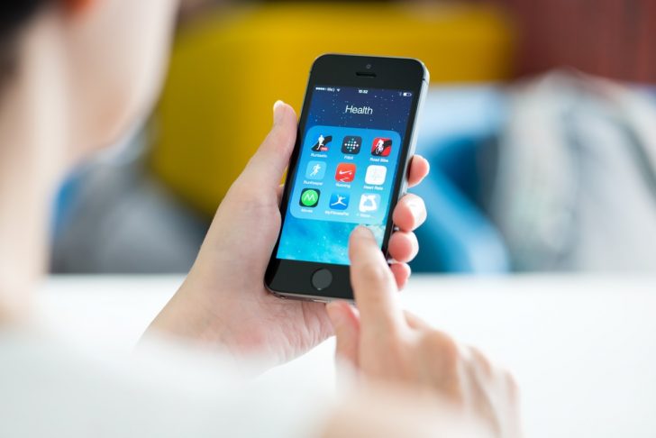 woman looking at fitness apps on smartphone