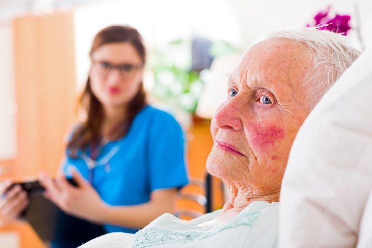 Young caretaker reading to Alzheimer's patient
