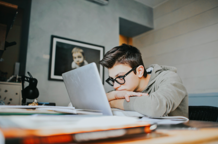 teen wearing glasses at computer
